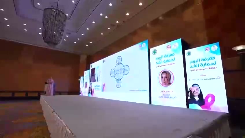 شاشات المسرح تعرض عنوان الملتقى وبطاقة المتحدثة د. سمر اكرام.